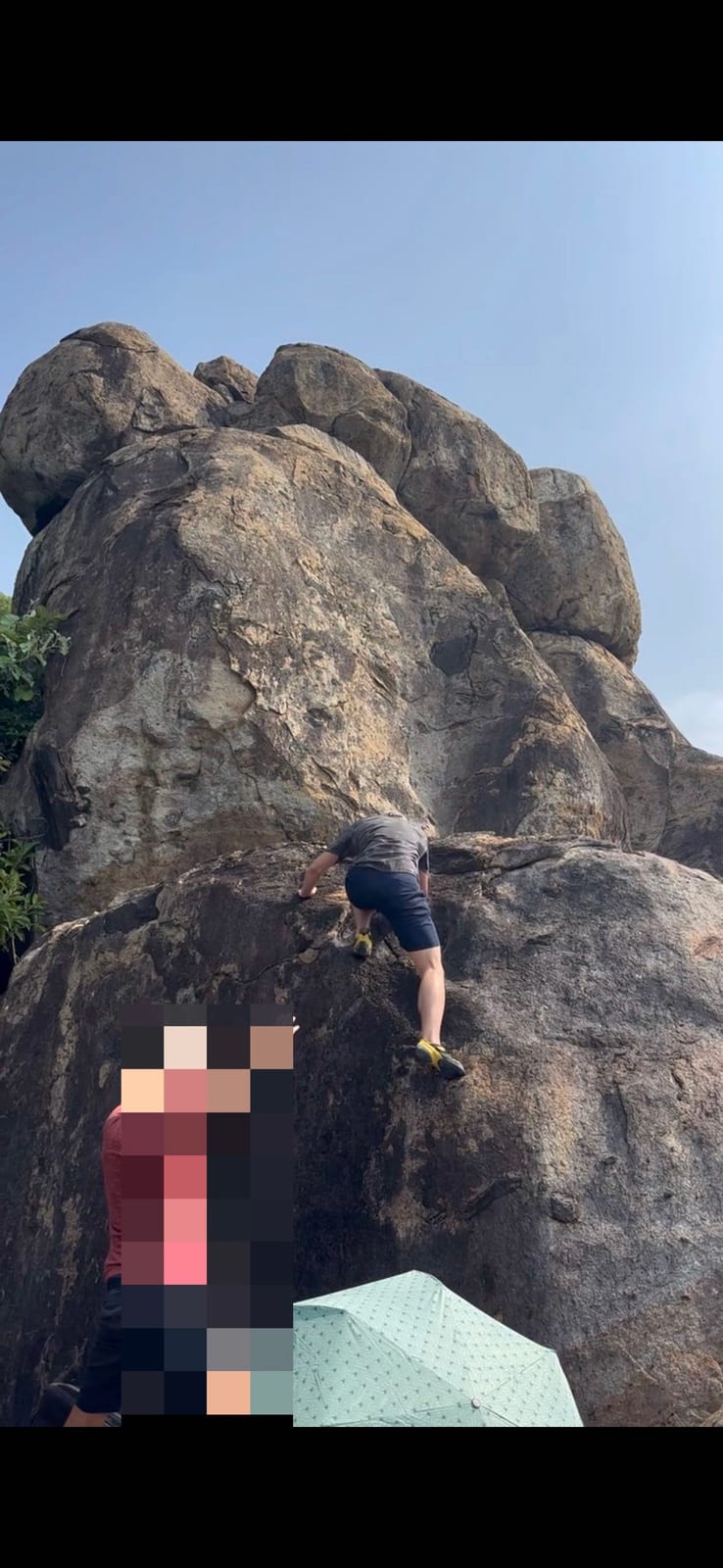 Climber topping out a granite boulder at Bai Xep, Son Tra, Da Nang