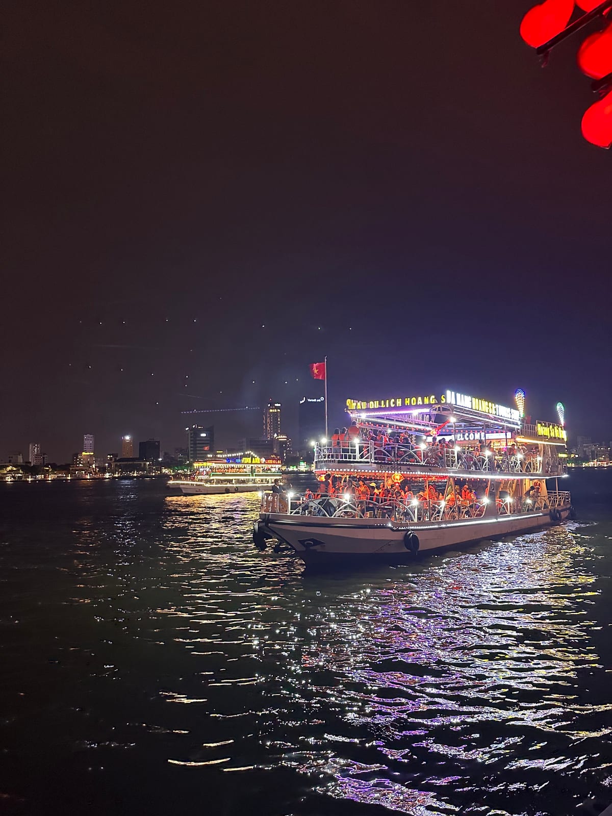 Night cruise boats lit up on the Han River in Da Nang