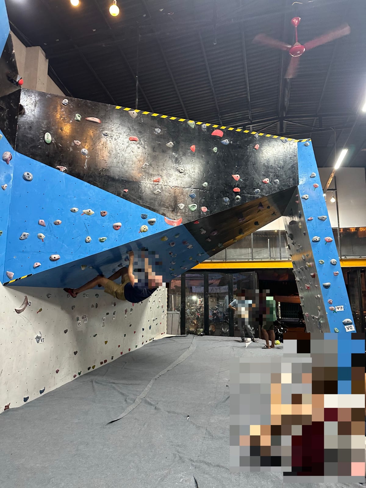 Indoor bouldering gym in Da Nang, Vietnam with an overhanging wall and V grade tags