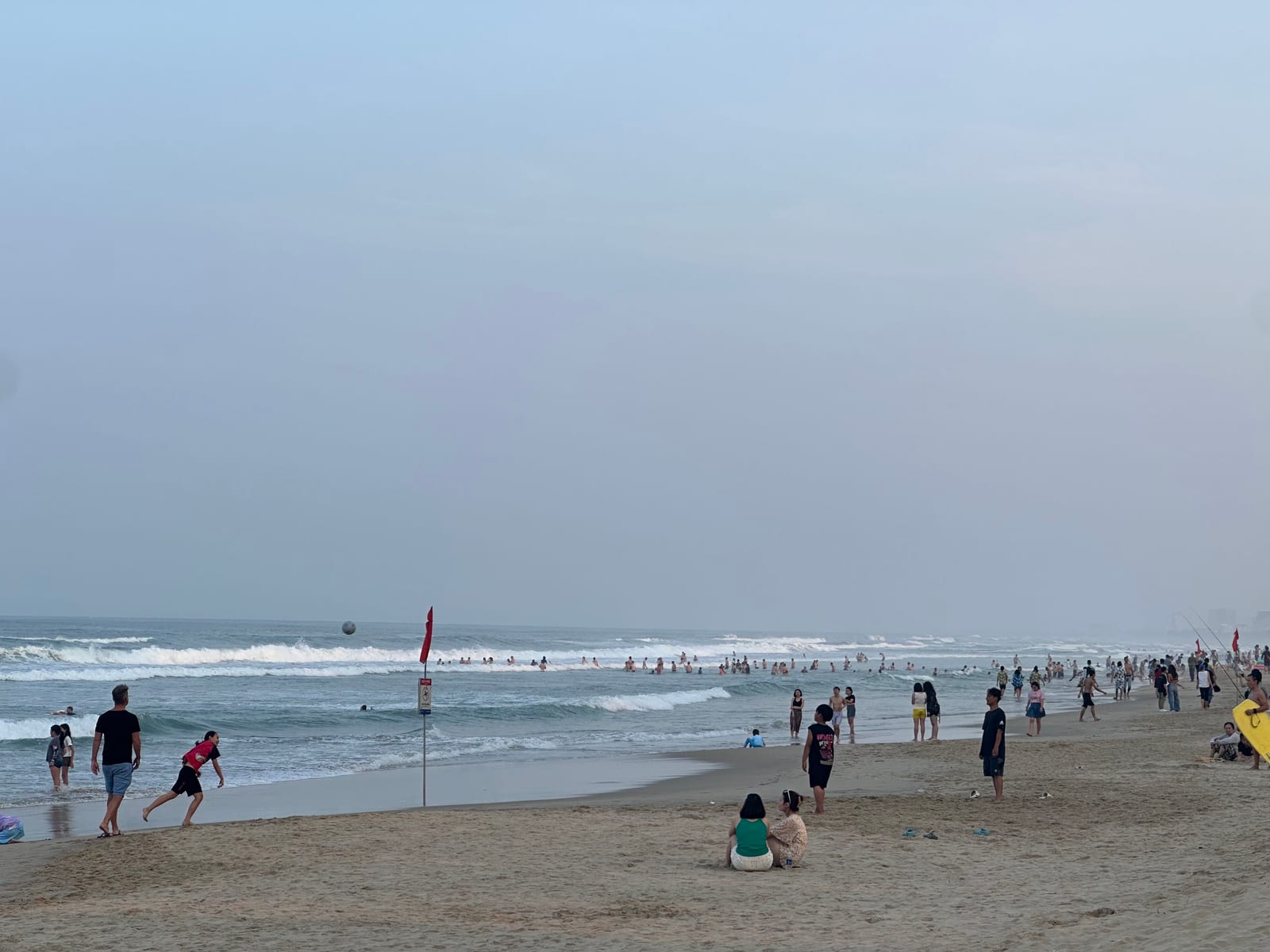 Swimmers and surfers in the water at My Khe beach, Da Nang, Vietnam