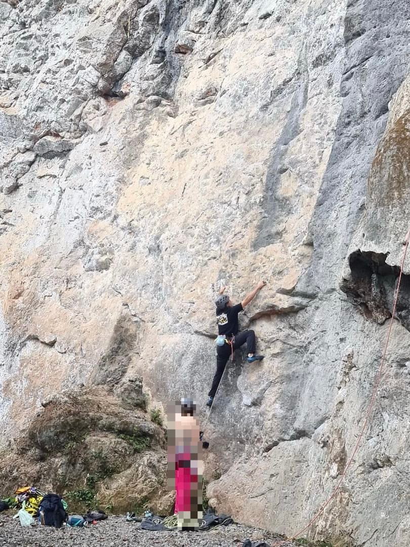 Climber on an easier 6a route at Riverside crag with belayer below, Yangshuo