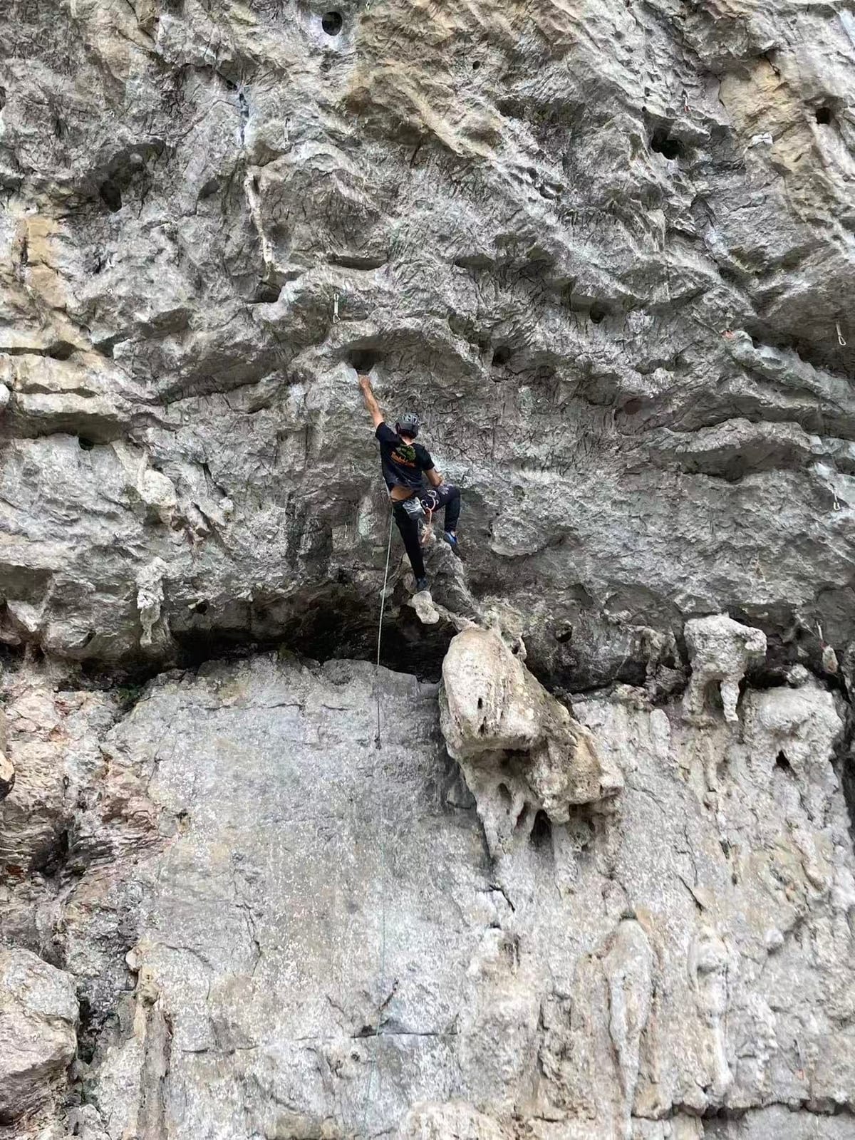 Climber pulling through the first crux of Dragonfly 7a+ at Riverside, Yangshuo