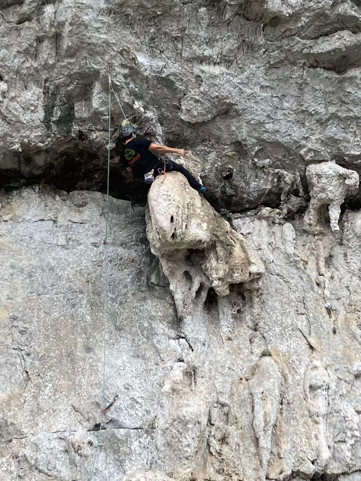 Climber resting on Dragonfly 7a+ at Riverside crag, Yangshuo