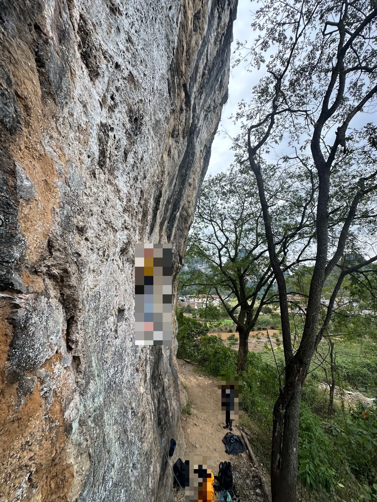 Climbers and belayers at the base of Spearhead crag, Yangshuo, China