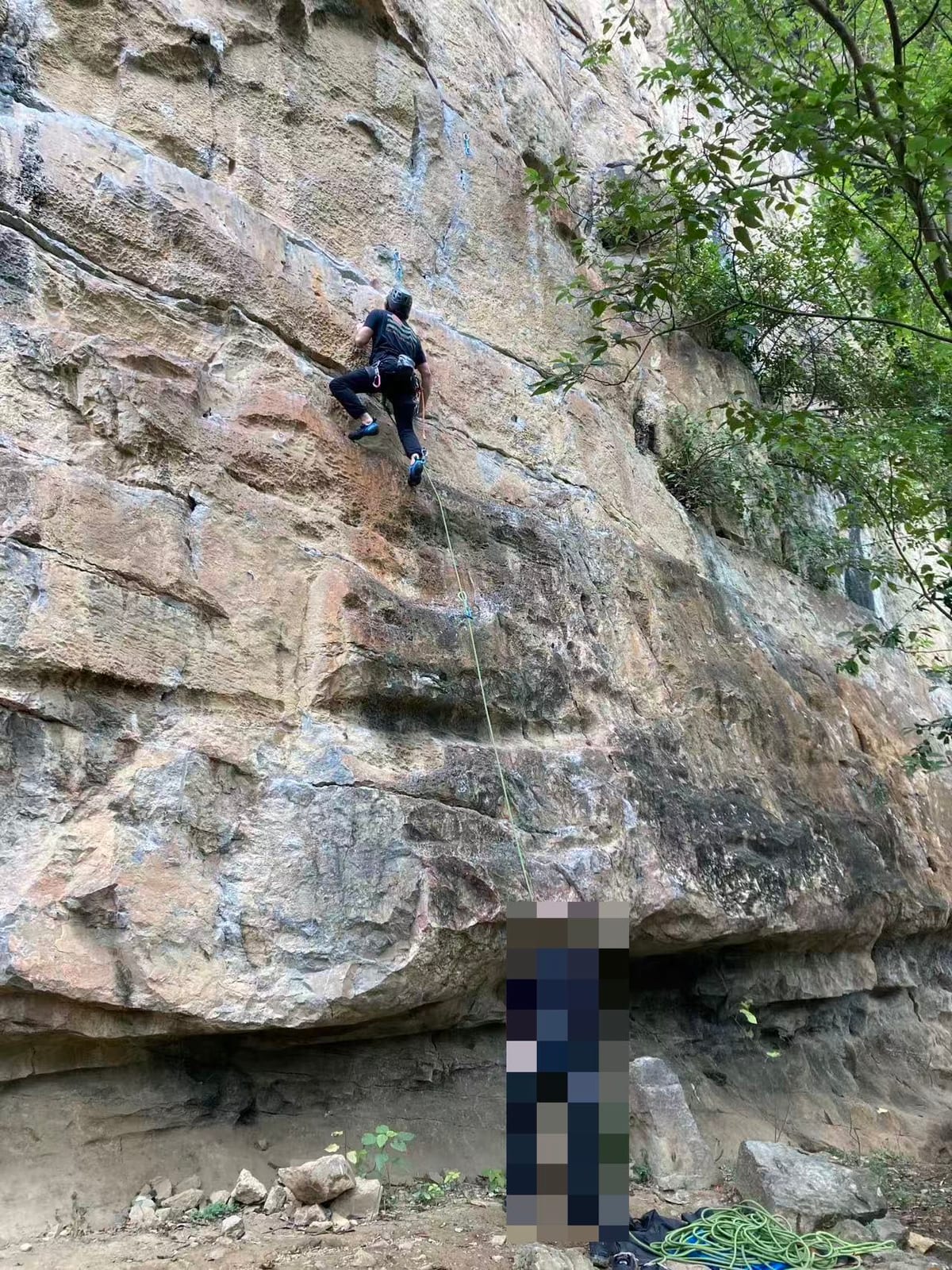 Climber on the upper wall of a route at Twin Gates crag, Yangshuo