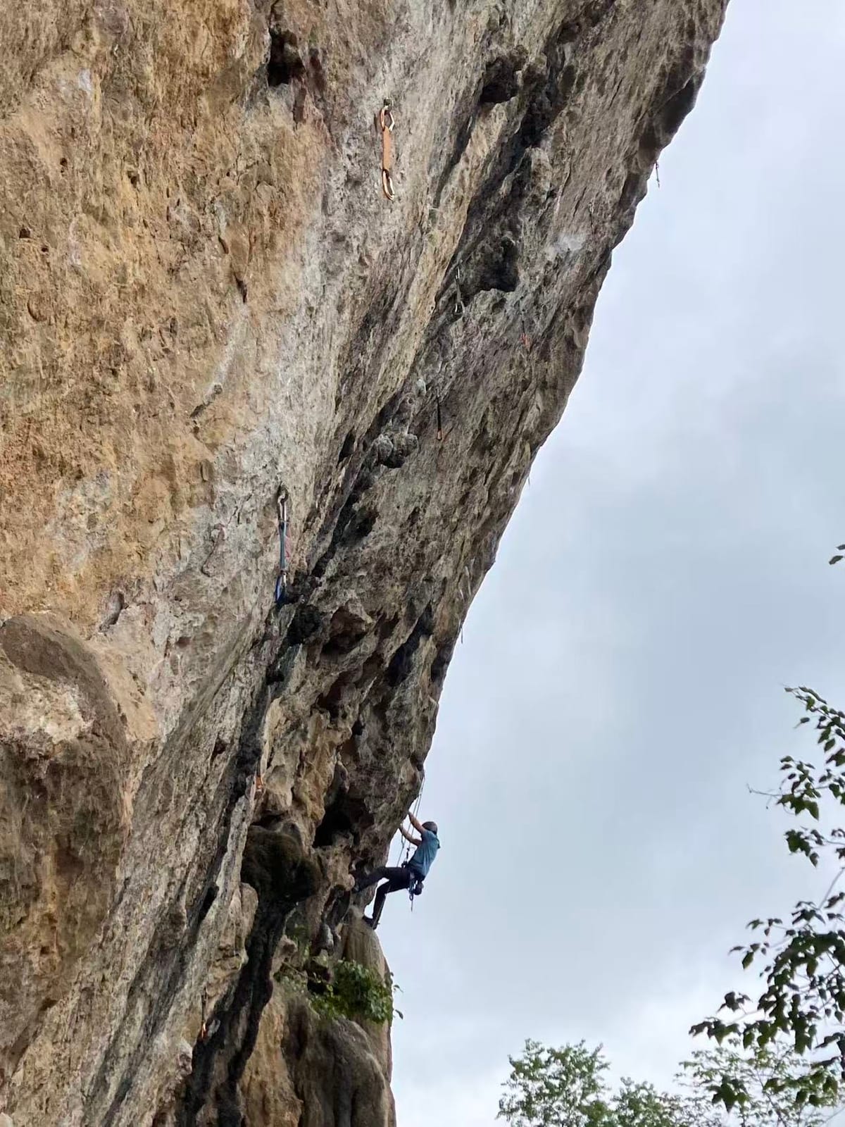 Climber on Aiding and Abetting 7a at White Mountain crag, Yangshuo