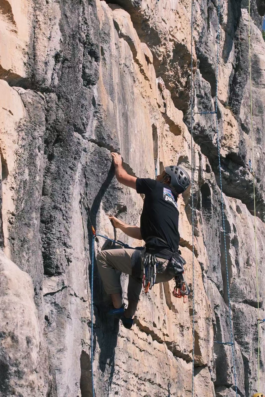 Climber crimping on a vertical route at Wine Bottle crag, Yangshuo