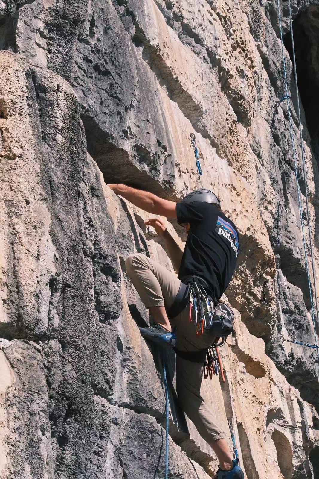 Climber high stepping on a vertical wall at Wine Bottle crag, Yangshuo, China