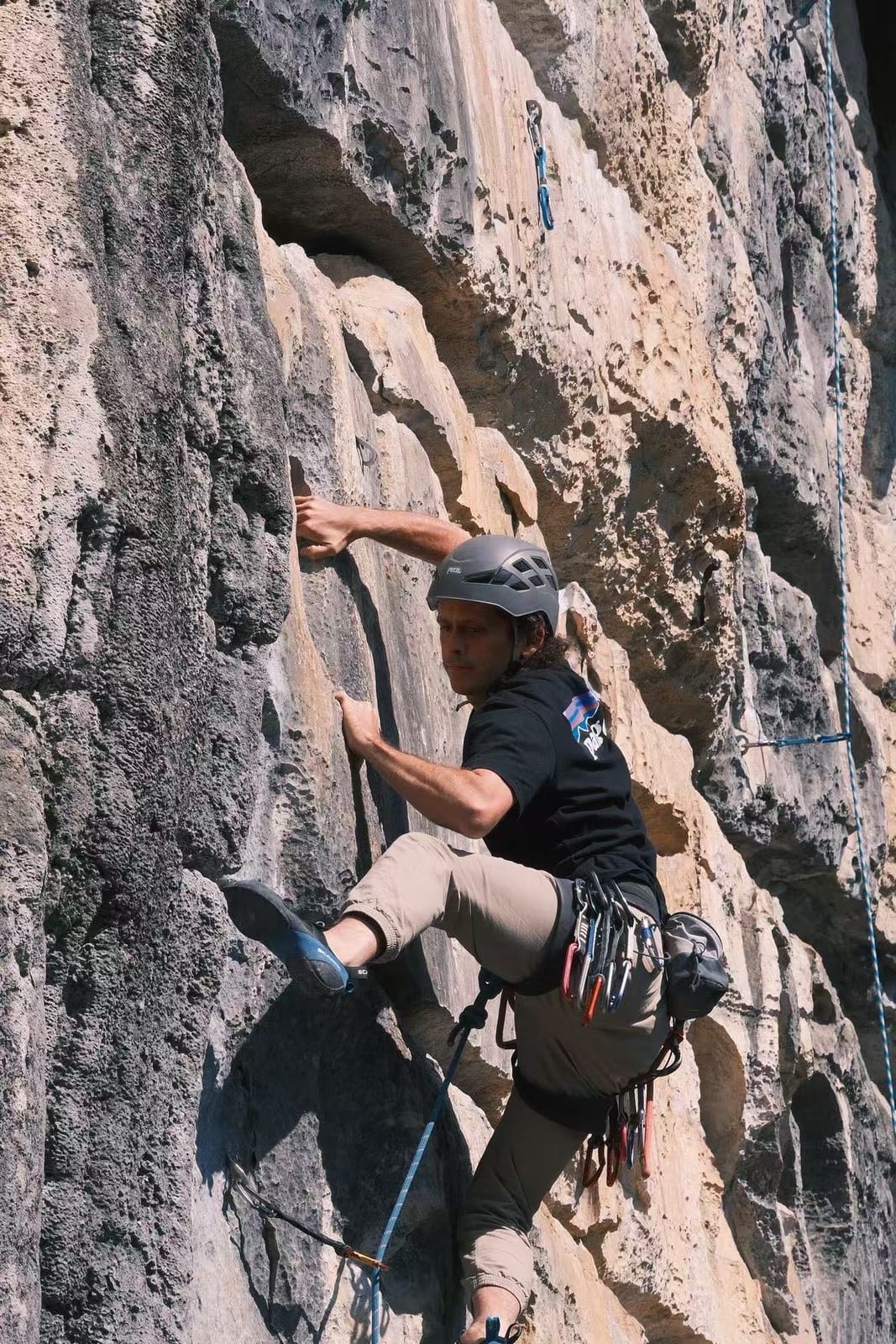 Climber making a long reach between crimps at Wine Bottle crag, Yangshuo